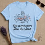 She Carries More Than She Shows botanical graphic tee for women