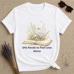 She Reads to Feel Less Alone — Open Book Garden T-Shirt for Women in White